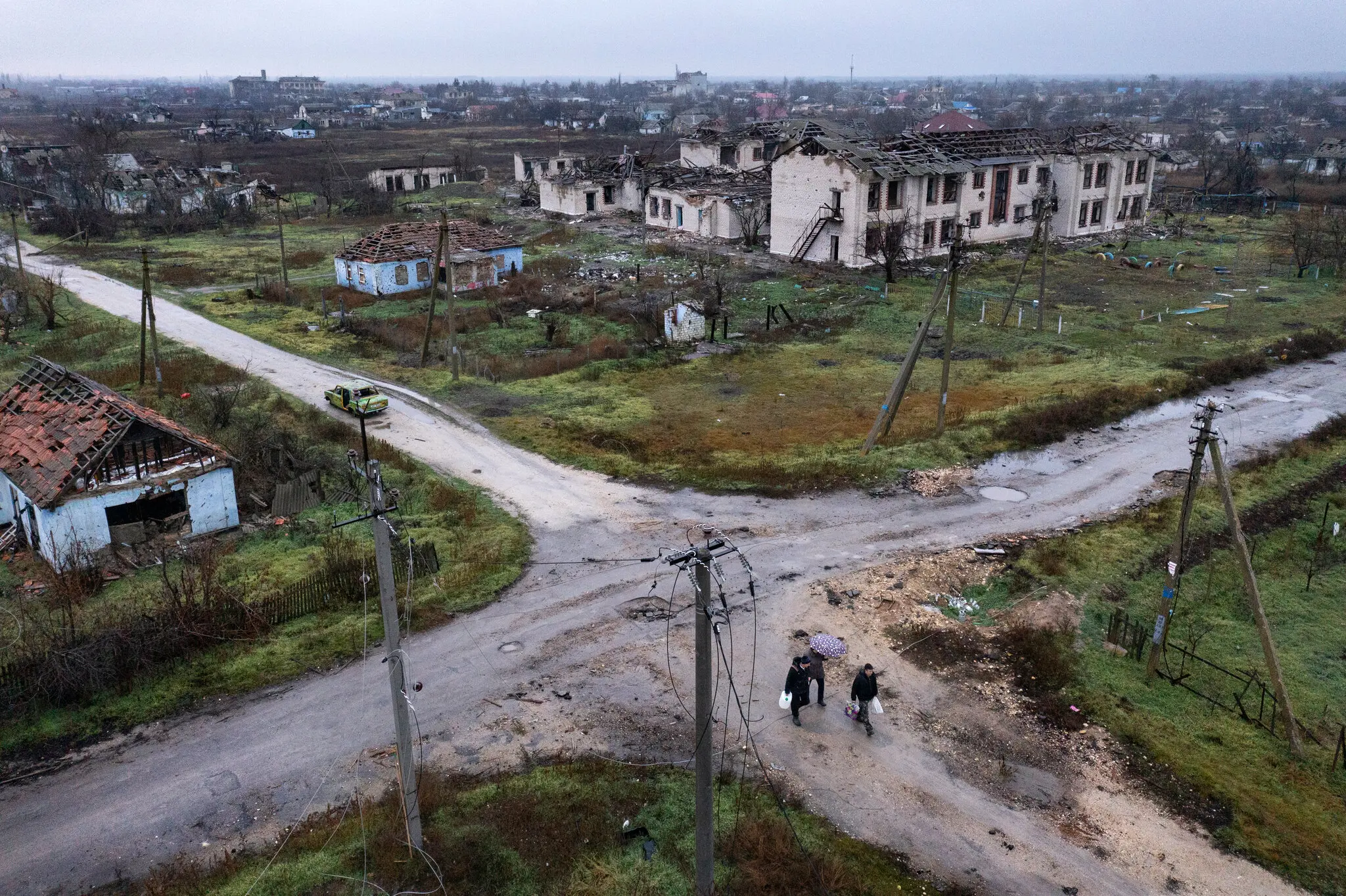Жителі несуть воду та припаси 9 грудня серед руйнувань у селі Посад-Покровське
